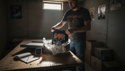 Collector storing vintage metal t-shirts in archival box
