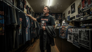 Heavy metal fan browsing vintage band t-shirts