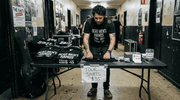 Band member setting up tour shirt merch table