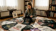 Person examining vintage band tees collection