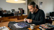 Man inspecting vintage heavy metal tour t-shirt