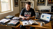 Man sorting vintage band shirts in home office