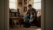 Man lacing boots in vintage heavy metal outfit