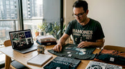 Collector examining band tees at table