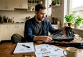 Man sorting vintage band t-shirts at home workspace