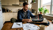 Man sorting vintage band t-shirts at home workspace