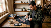 Man repairing metal shirt at casual kitchen table