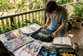 Collector examining vintage band shirts at table