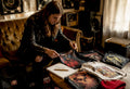 Person reviewing vintage heavy metal tour shirts collection
