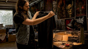 Collector examining vintage metal tee in room