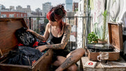 Person browsing alternative heavy metal clothing in apartment