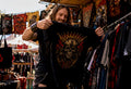 Man browsing vintage heavy metal apparel in thrift shop