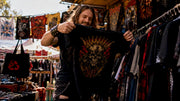 Man browsing vintage heavy metal apparel in thrift shop