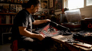 Collector examining vintage band t-shirt