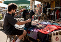 Man inspecting vintage heavy metal t shirts on coffee table
