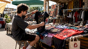 Man inspecting vintage heavy metal t shirts on coffee table