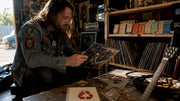 Man examining NWOTHM vinyl record in music studio