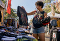 Person browsing vintage band shirts in store
