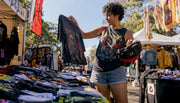 Person browsing vintage band shirts in store