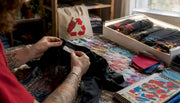 Hands inspecting tag and stitching of vintage tour shirt