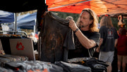 Collector examining vintage metal t-shirt closely