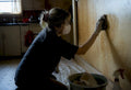 Person cleaning nicotine stain from wall
