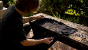 Hands inspecting vintage metal shirt fabric and print