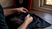 Hands inspecting Brockum tag on vintage metal shirt