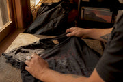 Hands inspecting vintage metal t-shirt details