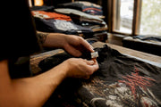 Hands inspecting vintage band tee tag and print
